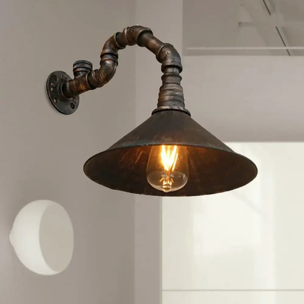 DecorBites™ antique brass wall sconce with dark rusted metal pipe arm and antique brass cone housing exposed bulb