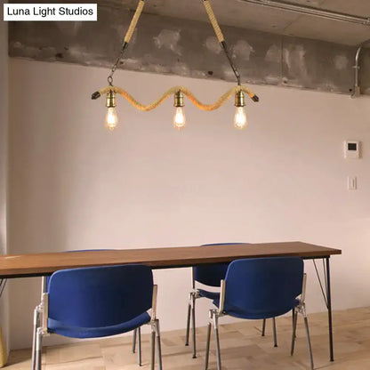 Industrial beige rope pendant light with three exposed bulbs suspended by braided rope and brass hardware for dining room