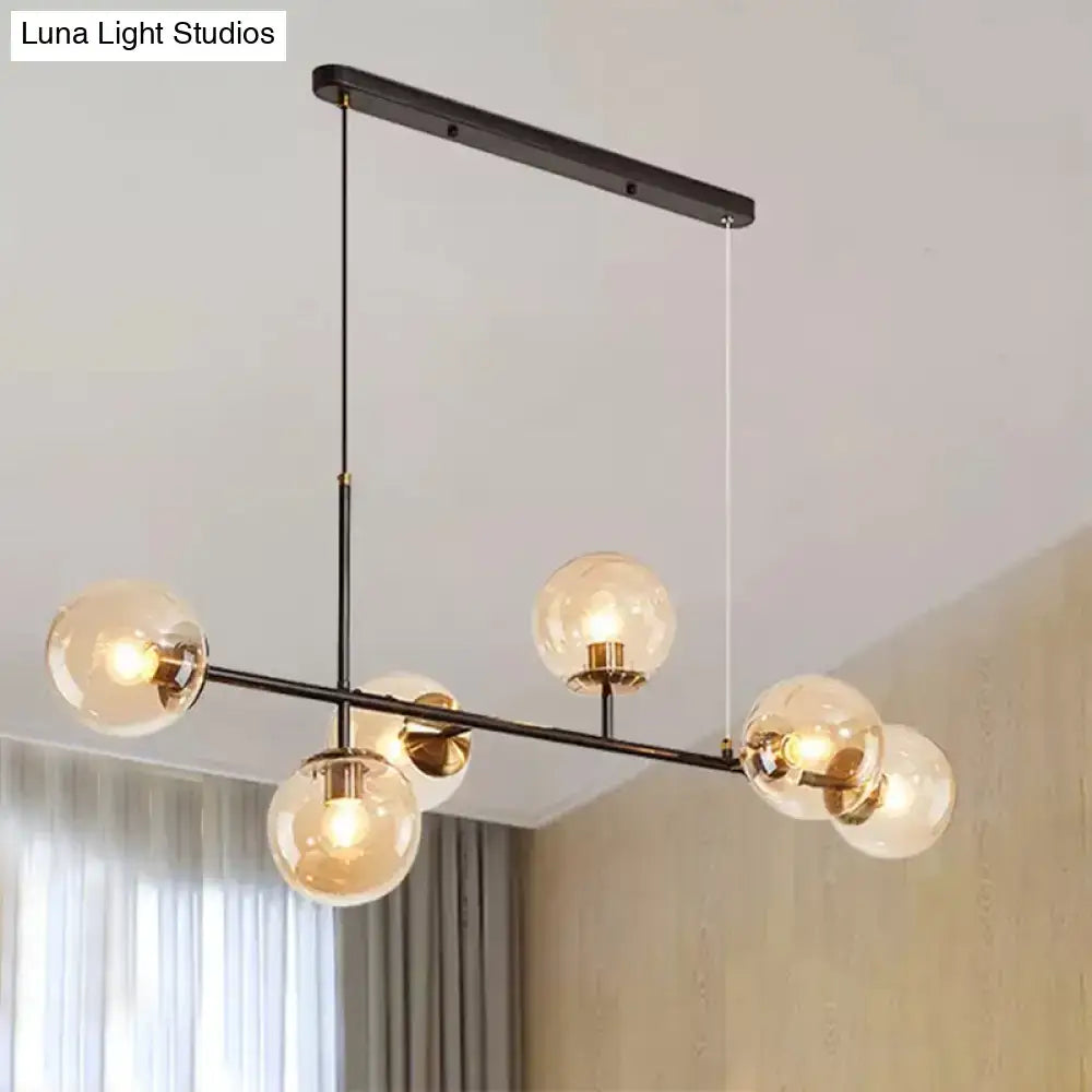 Modern black metal 6-light island pendant with clear glass globes brass accents and amber milky white gradient shades
