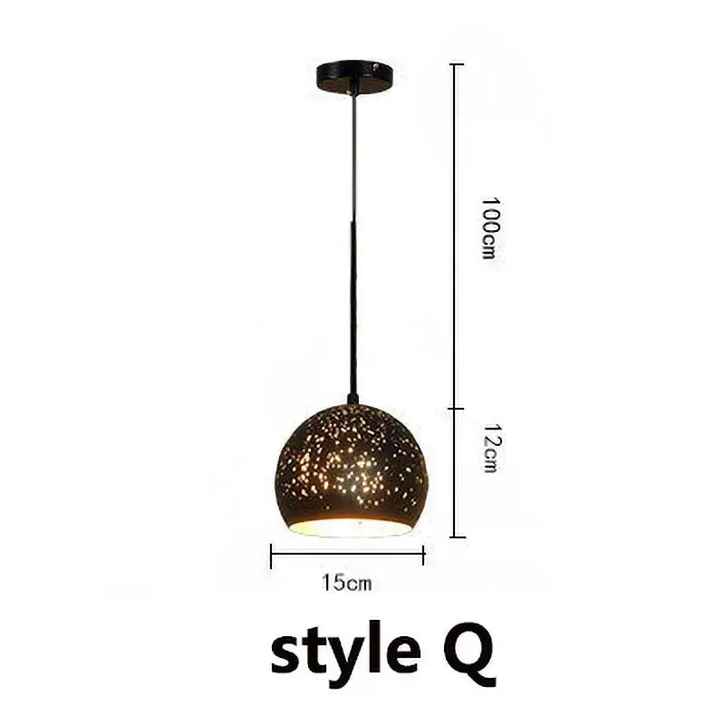 A sleek black pendant light with a speckled glass shade in an industrial black and gold etched wrought iron chandelier