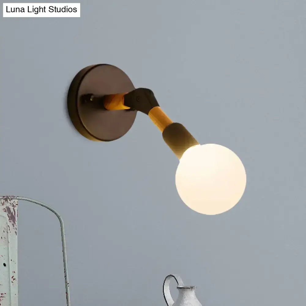 A modern industrial ocean blue wall sconce with matte bronze base, black and bamboo arm, and frosted globe bulb