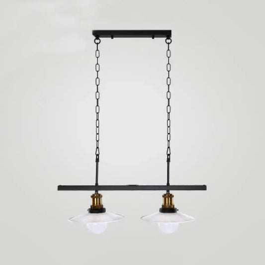 Black metal pendant light fixture with two clear glass shades and brass accents for kitchen island lighting