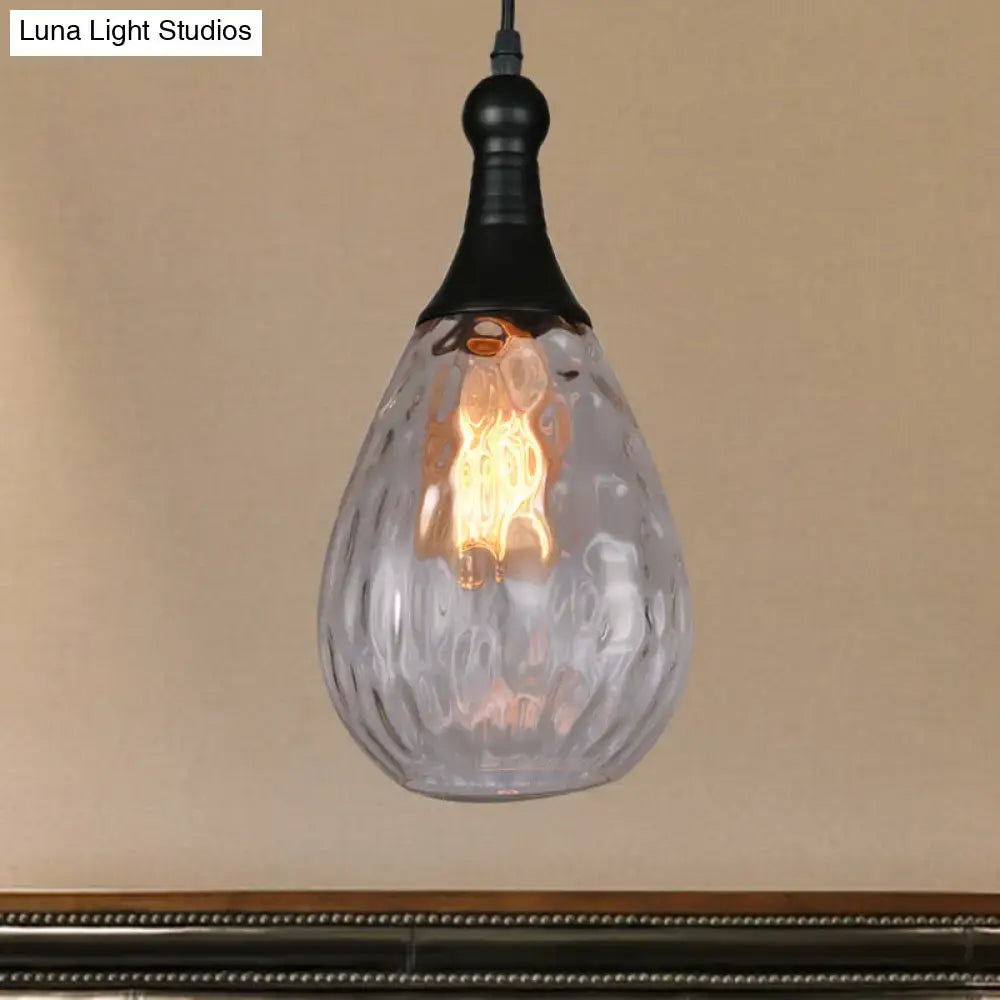 A teardrop-shaped clear glass ceiling light with textured surface and black metal fixture from DecorBites daisy industrial black brass collection