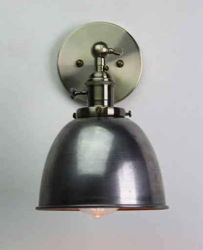 Industrial black wall sconce with matte black metal dome shade and brushed brass hardware for adjustable bedroom use