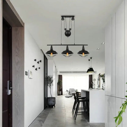 Black industrial farmhouse barn island pendant with three cage-shade lamps and adjustable chain cord length pulley mechanism