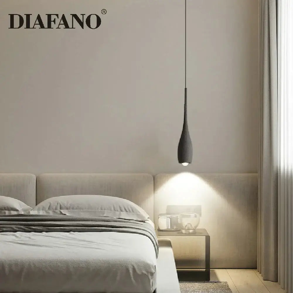 Industrial black matte cement pendant light with sleek teardrop design hanging above bedroom bed decorbites cement pendant