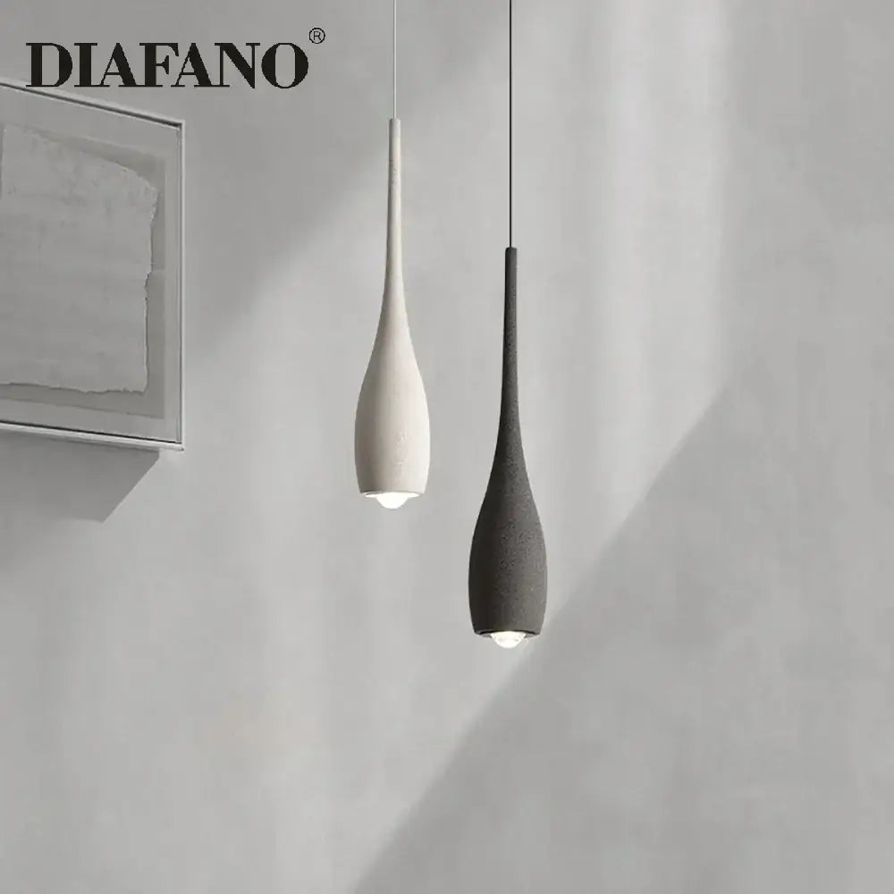 Two minimalist pendant lights by diafano with matte white and dark gray ceramic shades for decorbites cement pendant light