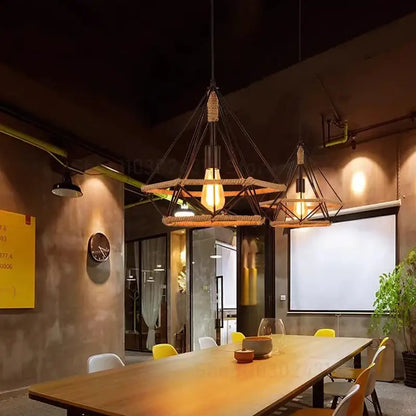 Industrial black metal pendant light with geometric frame woven rope accents and exposed incandescent bulb for dining room