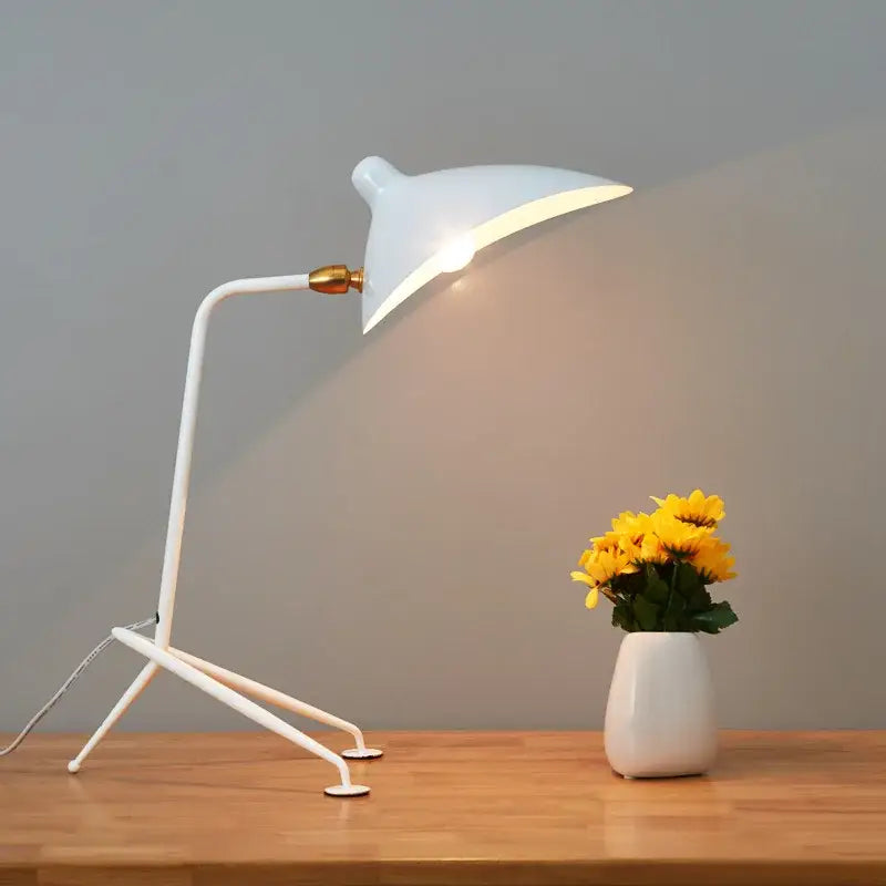 White minimalist desk lamp with curved neck and gold-toned joint paired with decorbites black serge floor lamp tripod base