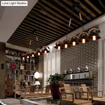 Industrial black metal island chandelier with dark metal shades and woven rope accents hanging from wooden ceiling