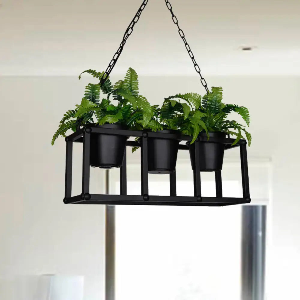 Black metal industrial rectangle island light fixture with three black metal hanging pots holding green ferns