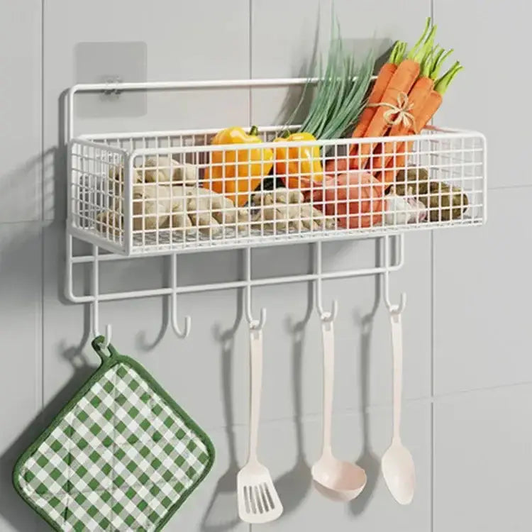 White wire mesh wall shelf organizer with five hooks holding vegetables and kitchen utensils for kitchen storage