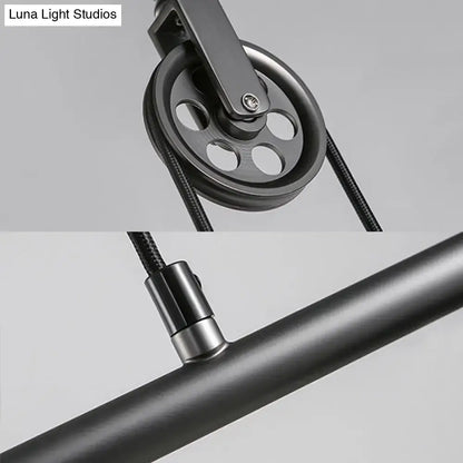 Black metal pulley with circular design and central screw attached to braided cable for DecorBites™ saucer foyer island ceiling light