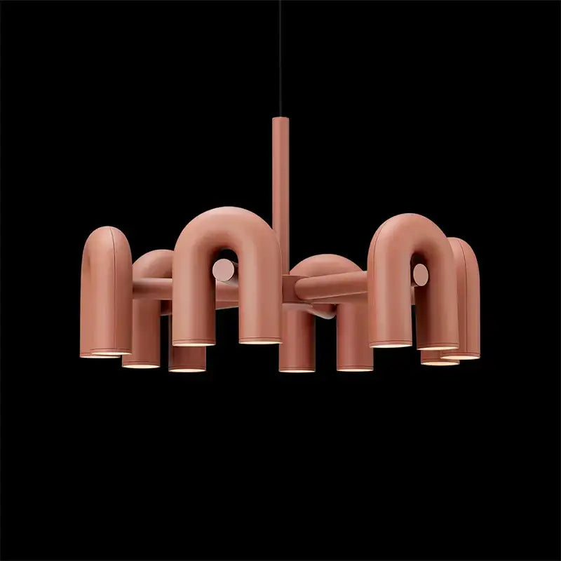 A modern matte rose gold geometric chandelier with u-shaped arms and cylindrical lights for decorbites cirkus led