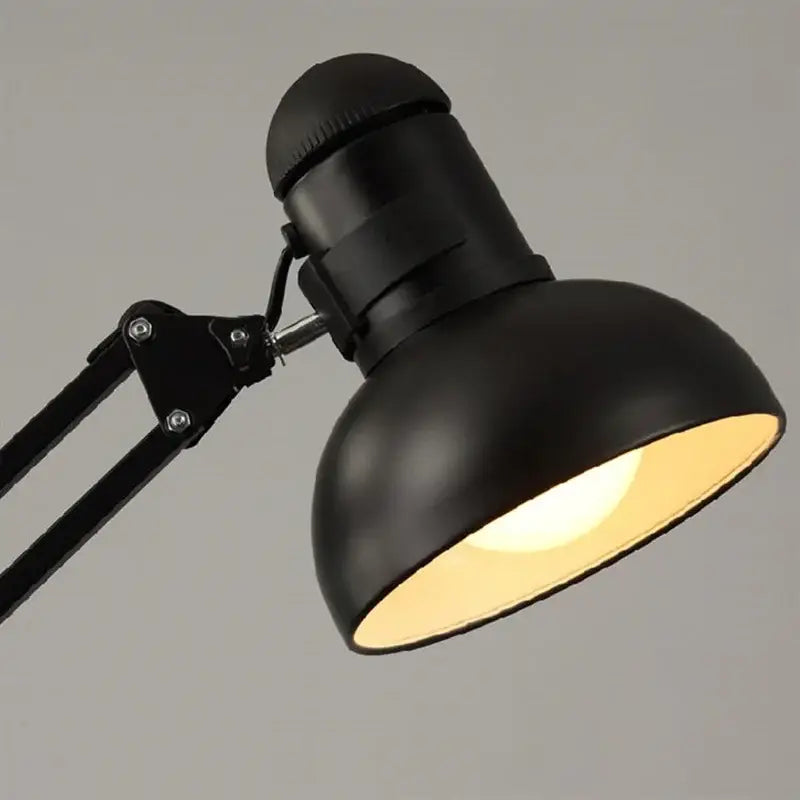 Black matte adjustable desk lamp with rounded dome shade paired with industrial black and white spider ceiling lamp