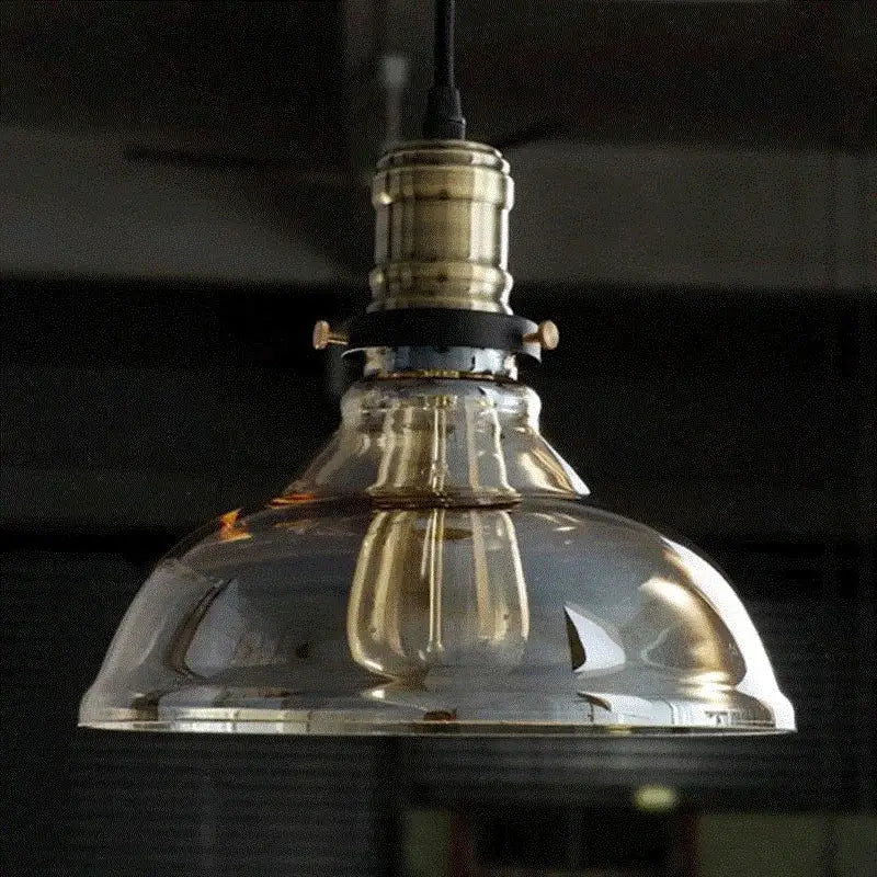 Industrial brass glass pendant light with clear glass dome and brass-finished metal fixture for dining room lighting
