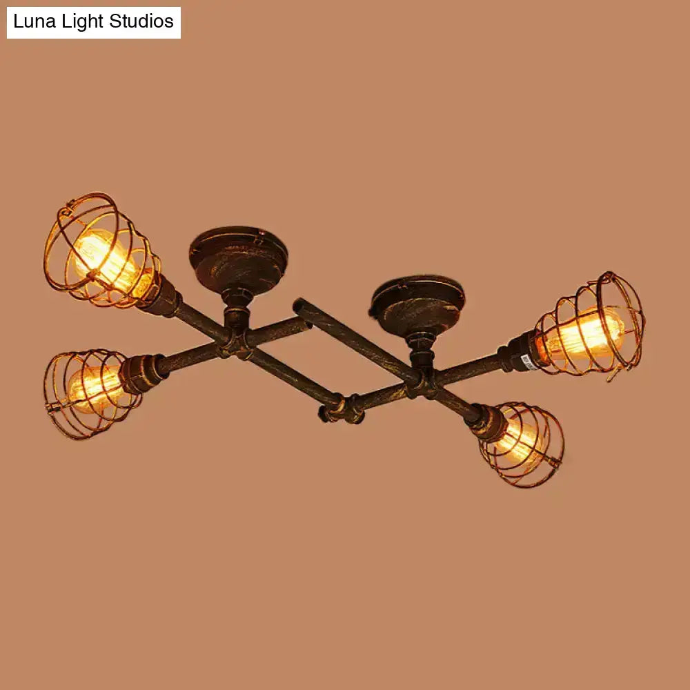 Industrial brass intersecting piping ceiling light with four exposed filament bulbs in wire cages on dark metal frame