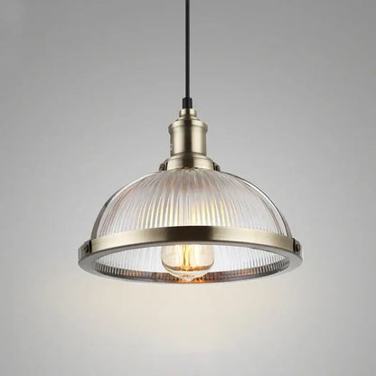 Industrial brushed nickel pendant light with a brass metal frame and ribbed clear glass shade for dining room