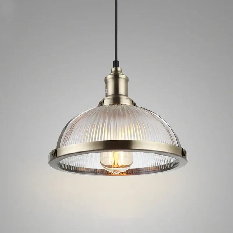 Industrial brushed nickel pendant light with a brass metal frame and ribbed clear glass shade for dining room