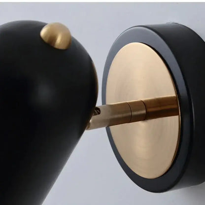 Industrial led wall sconce with black and brass minimalist design and rounded shade for bedroom spotlight use