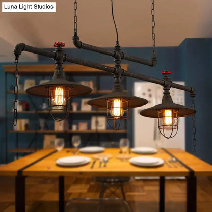 Industrial-style black pipe cone island pendant light with three exposed bulbs and red valve accents by decorbites
