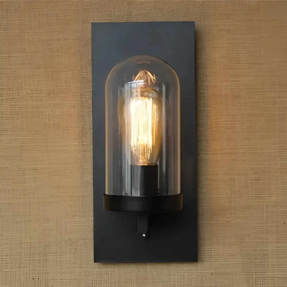 Black metal industrial Edison vintage wall sconce with clear glass dome and illuminated filament bulb for bedroom decorbites