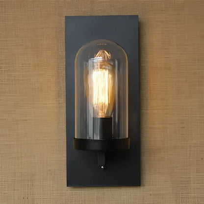 Black metal industrial Edison vintage wall sconce with clear glass dome and illuminated filament bulb for bedroom decorbites
