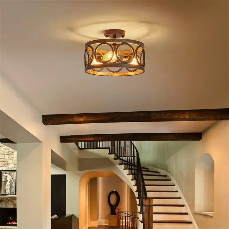 A rustic bronze finished industrial farmhouse circular chandelier with ornate metal frame and exposed bulb for dining room decorbites