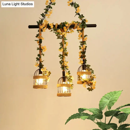 Three hanging black birdcage pendant lights with industrial hemp rope and yellow floral garlands for restaurant island lighting