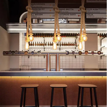 Thick natural-fiber hemp rope pendant light with warm edison bulbs above modern bar for dining room decorbites hemp rope chandelier