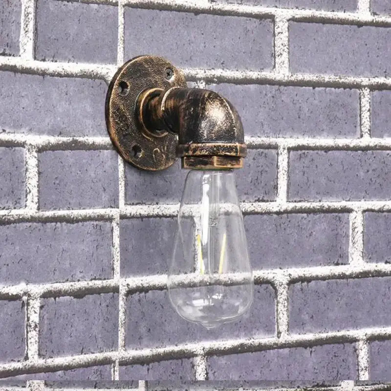 Industrial iron pipe wall sconce with brass finish and clear glass bulb featuring decorbites industrial iron design
