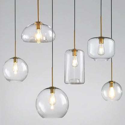 Industrial loft glass pendant light trio with clear glass, brass accents, and exposed filament bulbs for dining room decorbites industrial loft