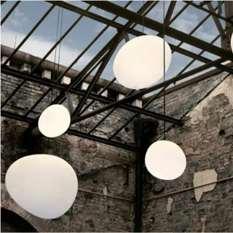Off-white industrial oval pendant light with white spherical shades hanging from metal ceiling for living room decorbites industrial living