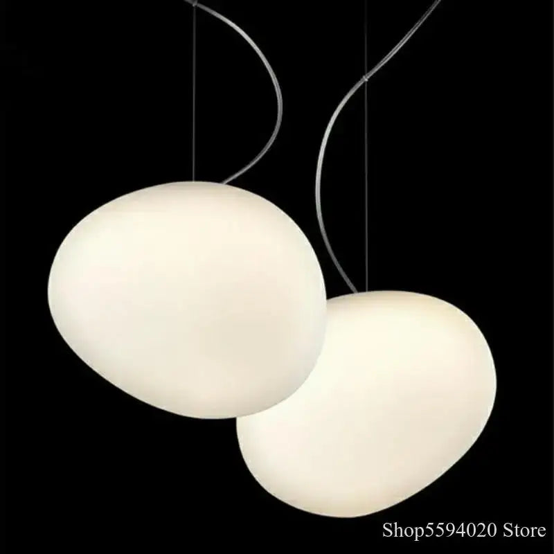 Two off-white industrial pendant lights with oval shapes and curved metallic cords for living room decorbites industrial living