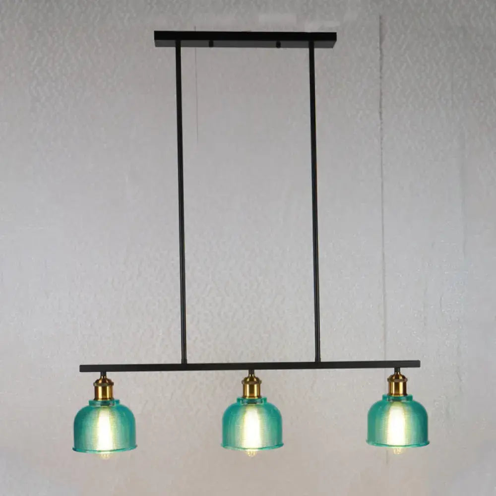 Modern black metal chandelier with three teal glass shades and brass accents for island lighting with red yellow blue bowls