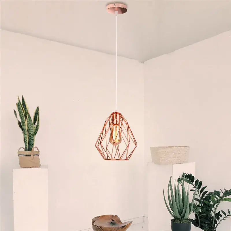 Industrial rose gold and black iron metal cage pendant light with exposed bulb and white cord for dining room decorbites iron metal