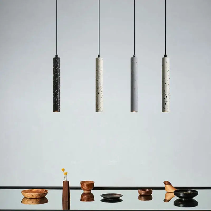 Four minimalist pendant lamps with speckled concrete finish and black cords from decorbites industrial stone led collection