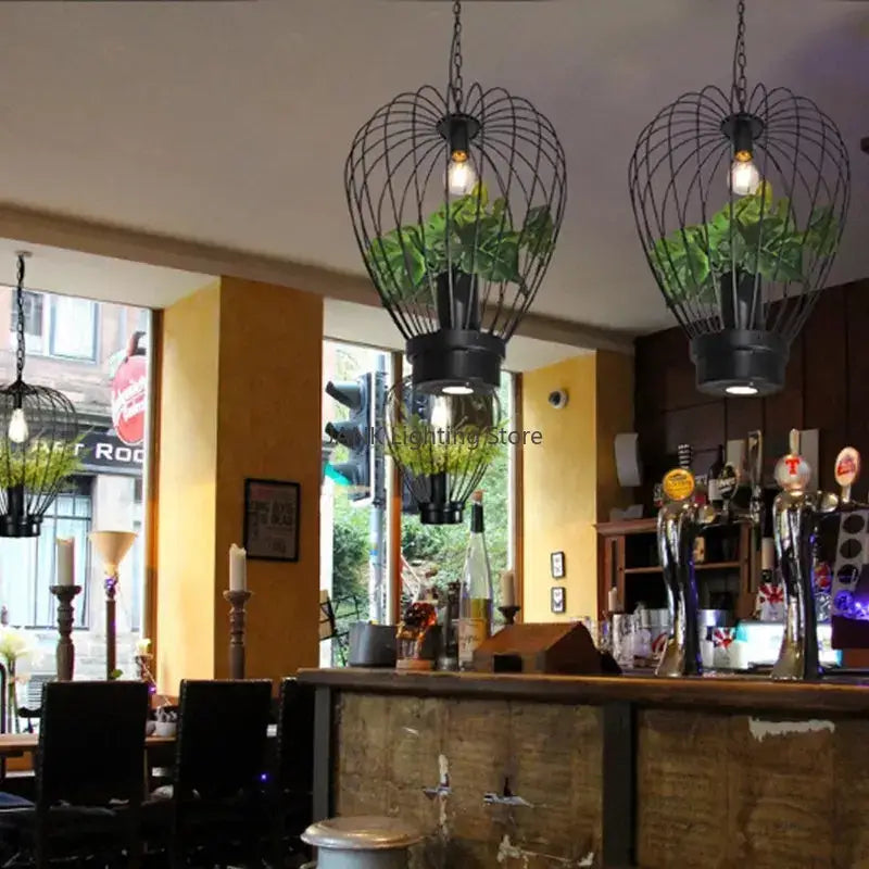 Black wrought iron pendant lamp with glass globes and green plants for industrial style planting decorbites dining room