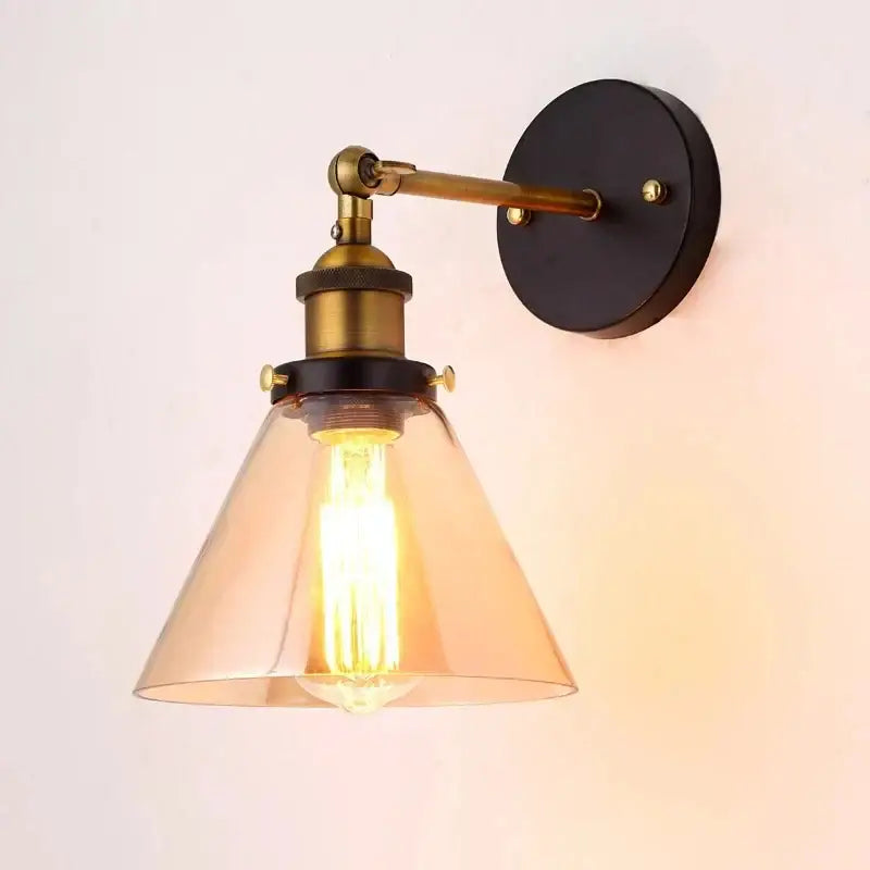 Industrial vintage black and brass wall sconce with amber glass shade and exposed filament bulb for decorbites industrial vintage loft decor
