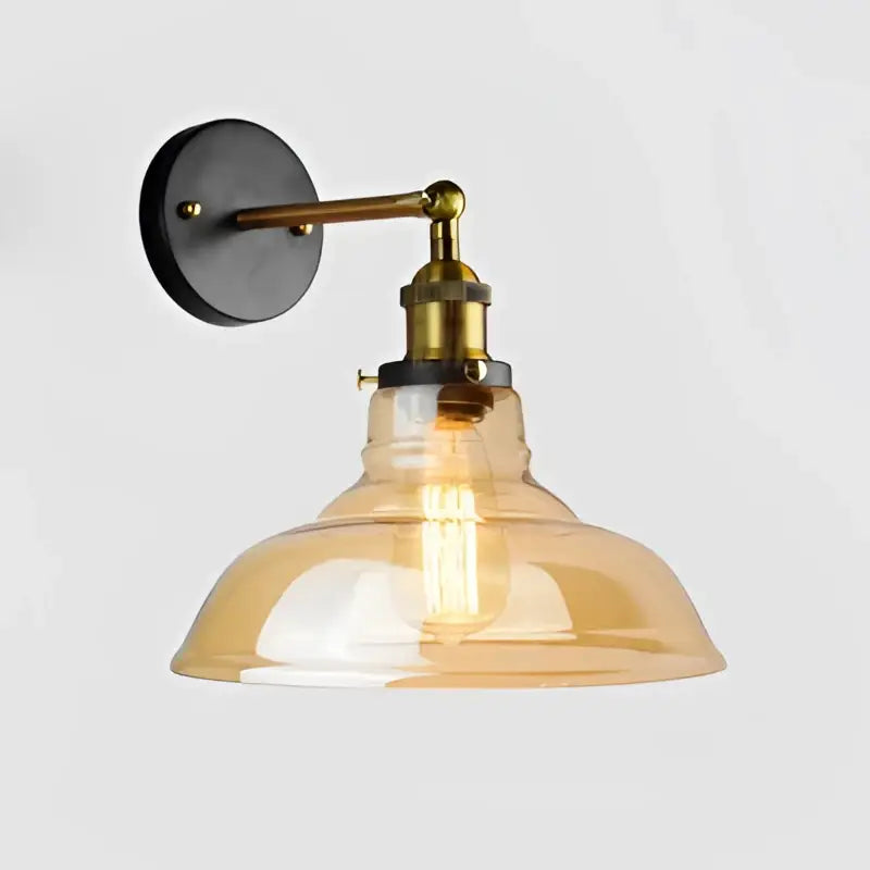 Industrial vintage black and brass wall sconce with amber glass shade and visible filament bulb for decorbites industrial vintage loft decor
