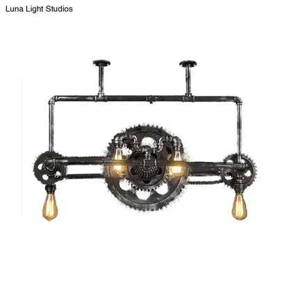 Industrial vintage black gear chandelier with dark rustic metal frame and three amber filament bulbs for dining room