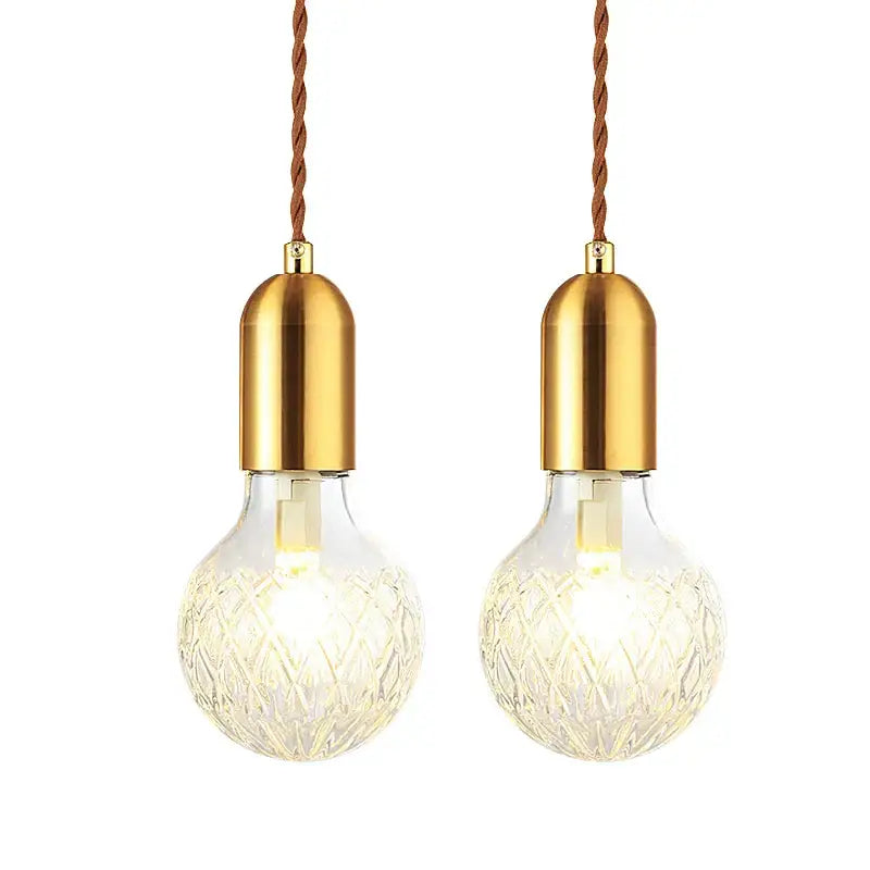 Two brass-finished industrial vintage pendant lights with faceted glass globes and twisted brown cords decorbites set of 2