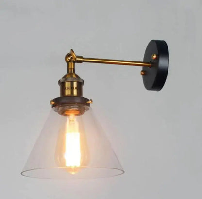 Industrial vintage brass wall sconce with black circular base and clear glass shade featuring exposed Edison bulb decorbites industrial vintage