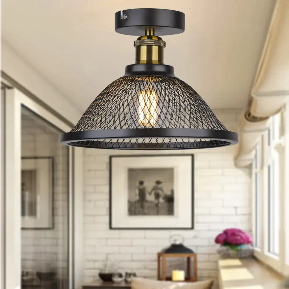 Black metal industrial vintage cage ceiling light with brass central stem and exposed Edison bulb for kitchen decorbites