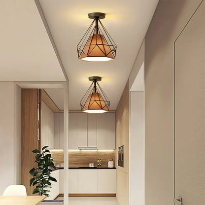 Industrial vintage ceiling light with geometric black metal frame and warm amber glass shade for living room decorbites
