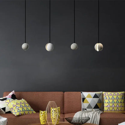 Four minimalist spherical pendant lamps with matte white industrial vintage cement finish hang against dark wall for kitchen decorbites industrial vintage design