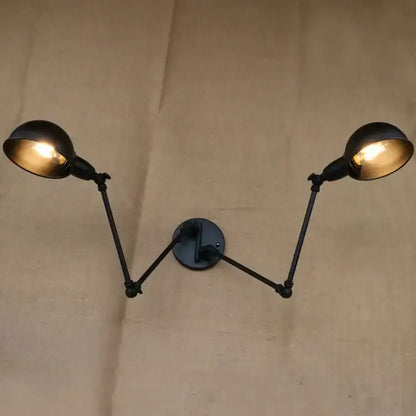 Black industrial vintage double brass wall sconce with two adjustable arms and dome-shaped light fixtures for decorbites