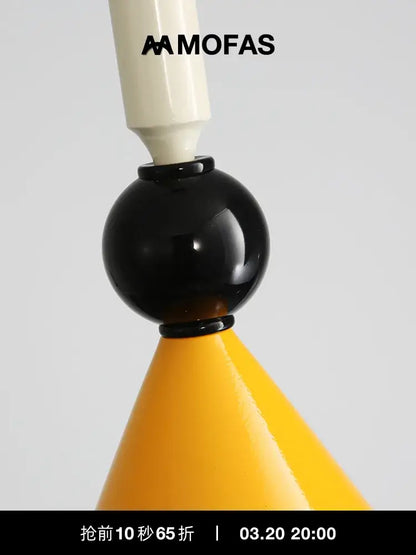 A sleek industrial vintage pendant light with a glossy black middle, cream top, and yellow conical base decorbites pendant light