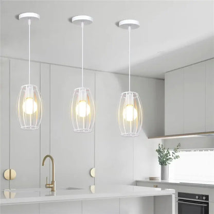 Three modern white wrought cage pendant lights with clear glass hang above a kitchen island decorbites industrial vintage