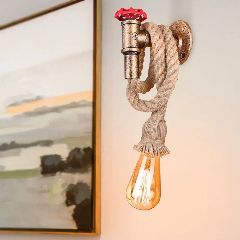 Industrial water pipe wall sconce in black and brass with red valve, beige rope, and amber glass bulb by decorbites industrial water
